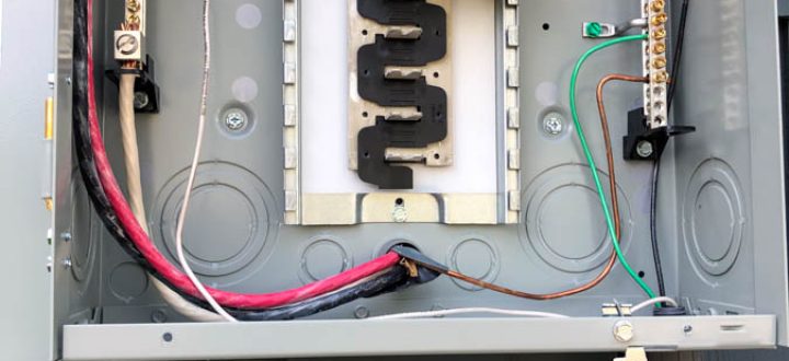 An open outdoor electrical panel with various colored wires connected, showcasing detailed electrical installation work.